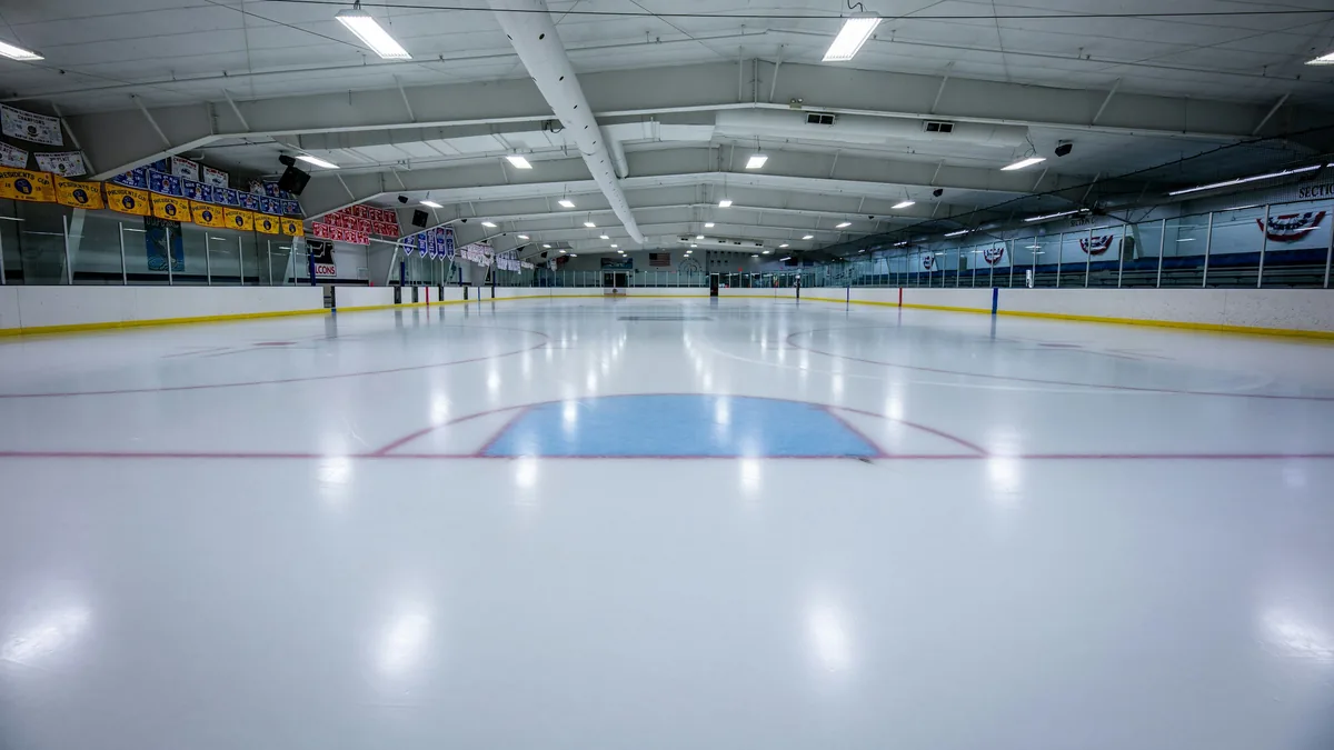 An empty indoor rink seen from centre ice