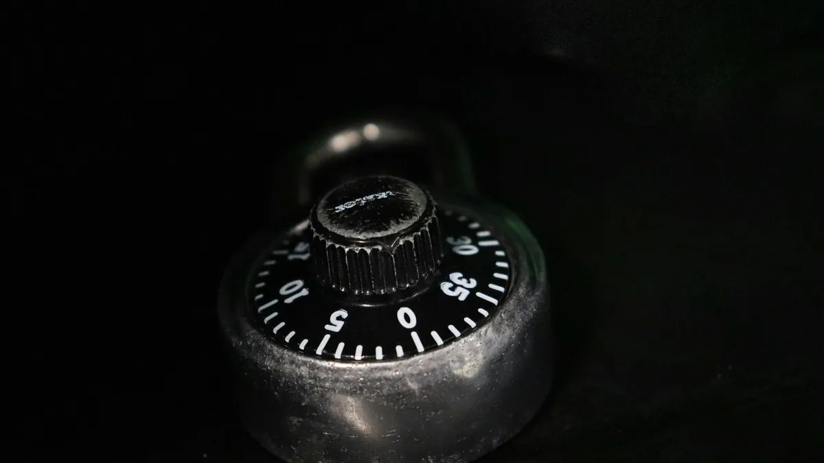 A combination padlock dial on a black surface