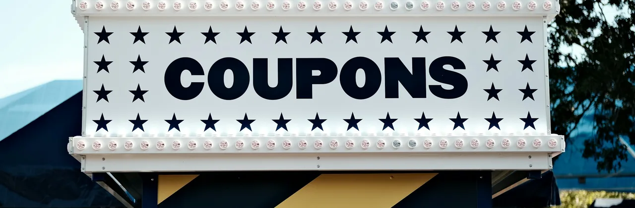 A fairground booth whose sign reads COUPONS